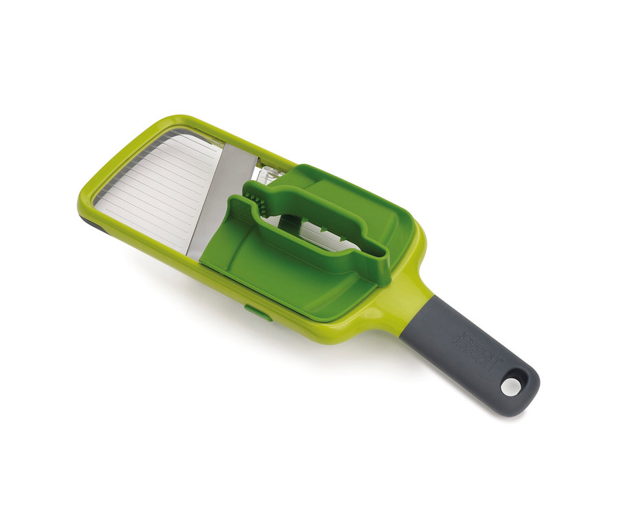 Eine grüne Joseph Joseph Multi-Grip »Mandoline™« Reibe liegt auf einem weißen Hintergrund.