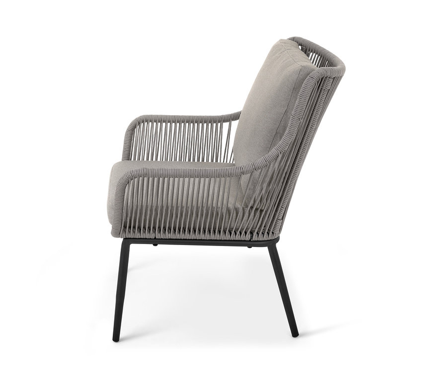 Seitenansicht eines Sessels aus einem Gartensofa-Set aus Textilgeflecht mit grauen Kissen.