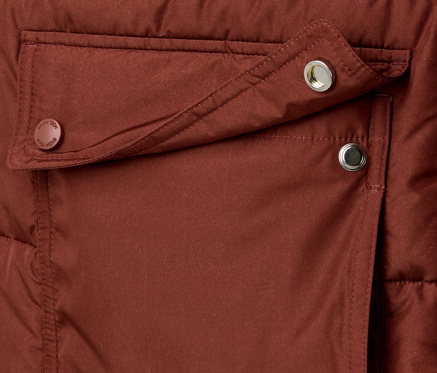 Detailansicht einer Kapuzen-Steppmantel-Tasche mit Druckknöpfen.