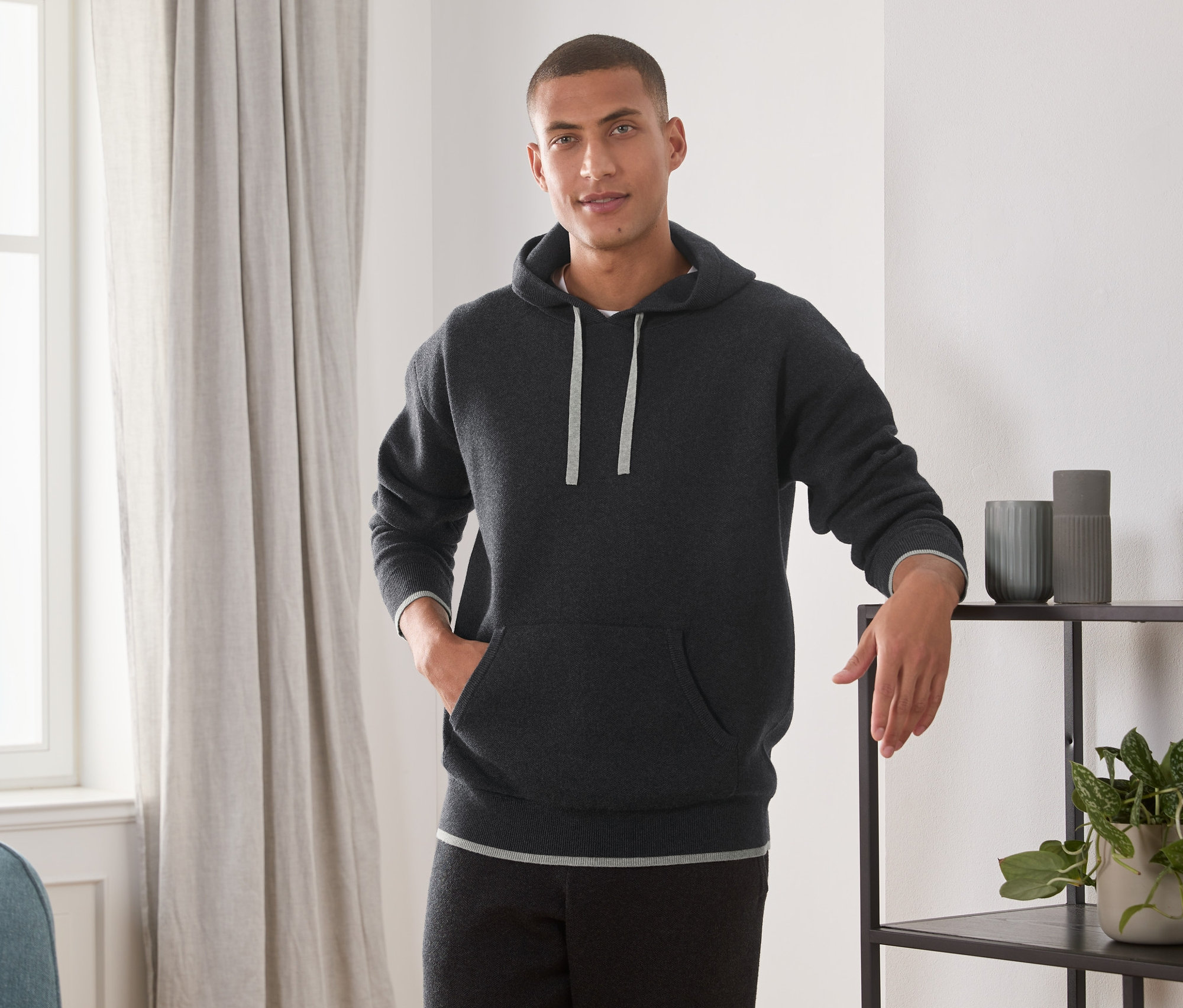Mann posiert im Strick-Hoodie.