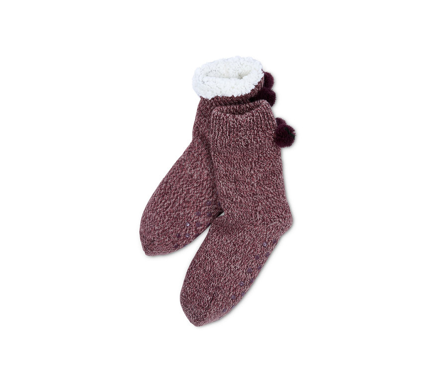 Ein Paar Hausschuh-Socken in meliertem Lila mit weißem Plüschrand und Bommeln.