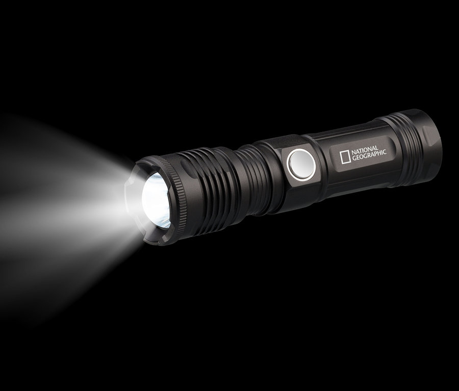 Eine schwarze LED-Taschenlampe leuchtet vor einem schwarzen Hintergrund. Zu sehen ist die NATIONAL GEOGRAPHIC ILUMINOS 1000 LED-Zoom-Taschenlampe.