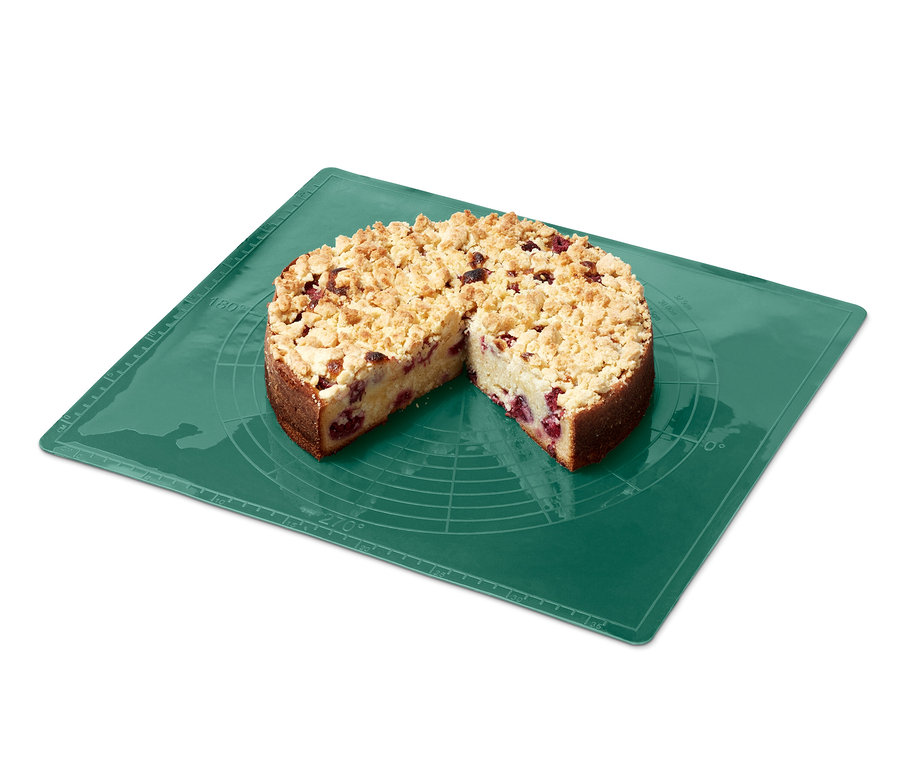 Ein angeschnittener Kuchen auf einer grünen Dauerbackmatte.