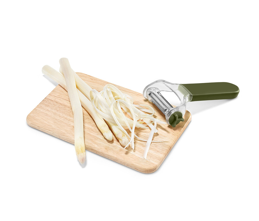 Drei Stangen weisser Spargel, Spargelspäne und ein 3-in-1-Universalschäler liegen auf einem Holzbrett.