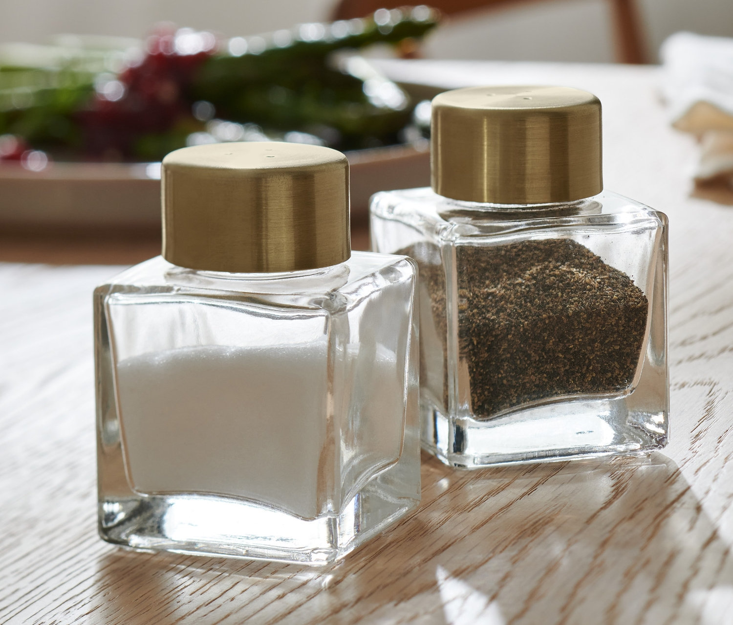 Auf einem Holztisch stehen Salz- und Pfefferstreuer.