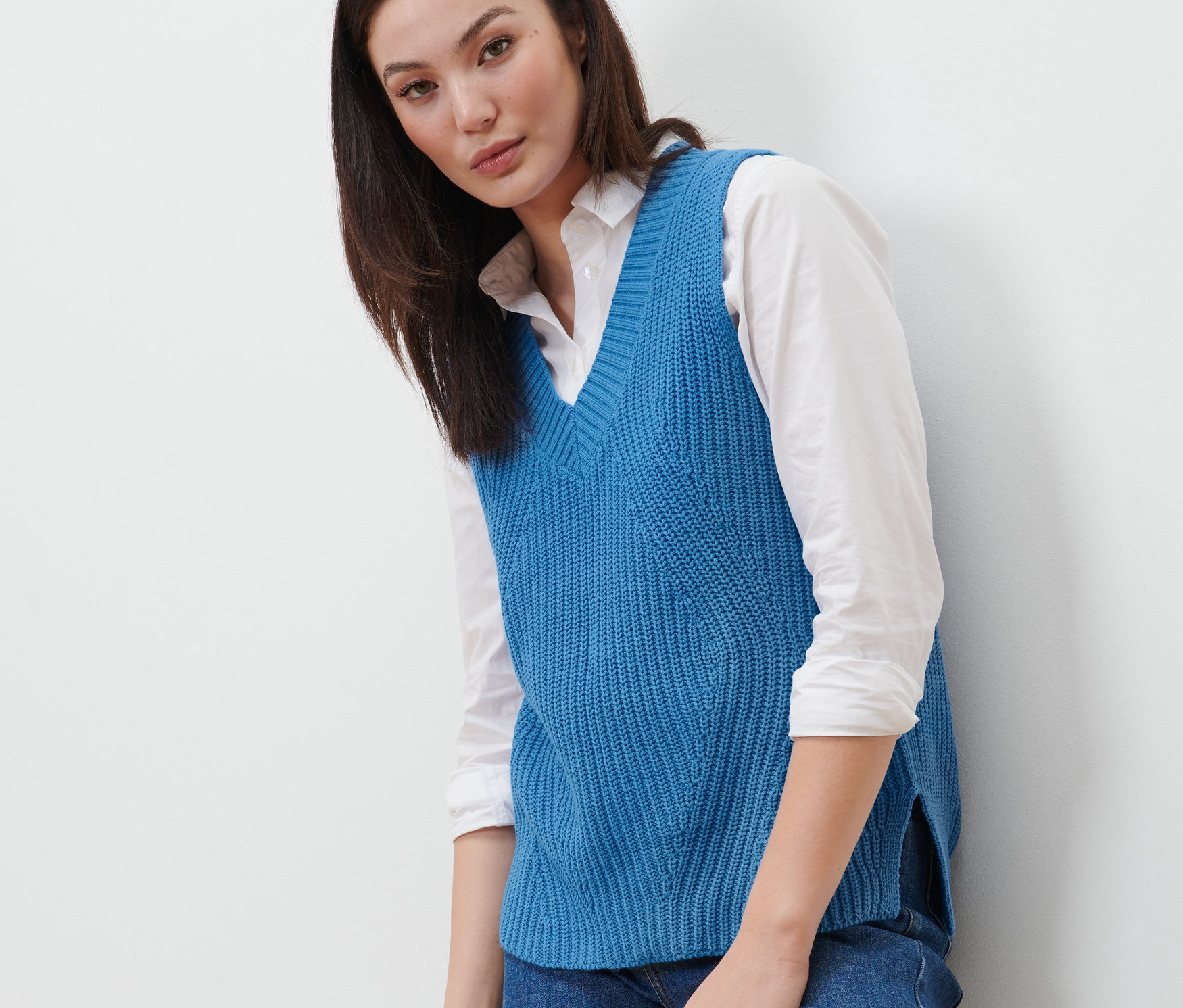 Frau trägt einen blauen Strick-Pullunder.