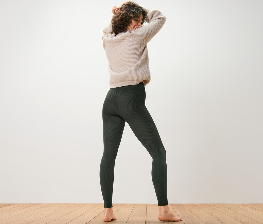 Frau steht mit dem Rücken zur Kamera und trägt gerippte Thermoleggings.