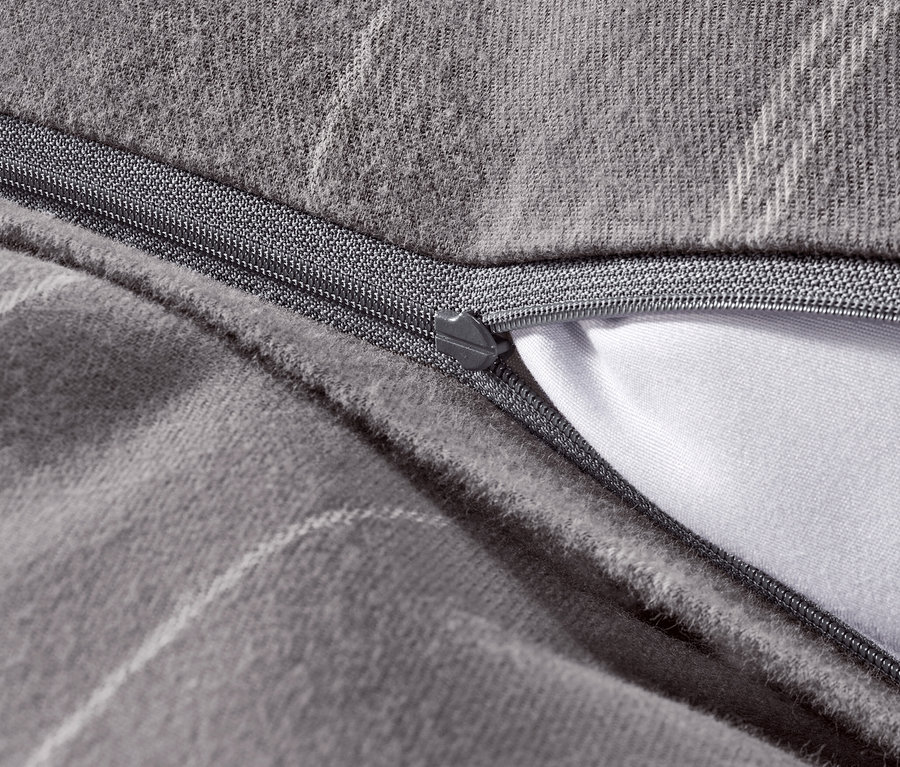 Detailaufnahme von grauer Flanell-Bettwäsche mit Reißverschluss.