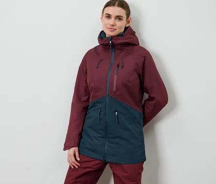 Frau posiert in Ski-und-Snowboardjacke.