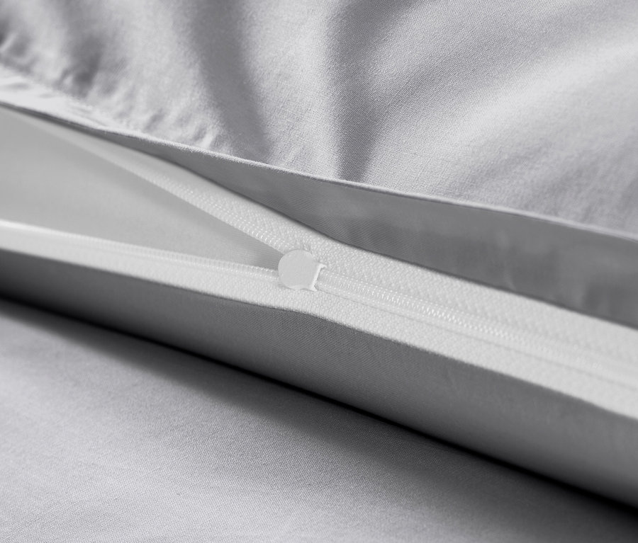 Detailansicht grauer Baumwollsatin-Bettwäsche mit Reißverschluss.