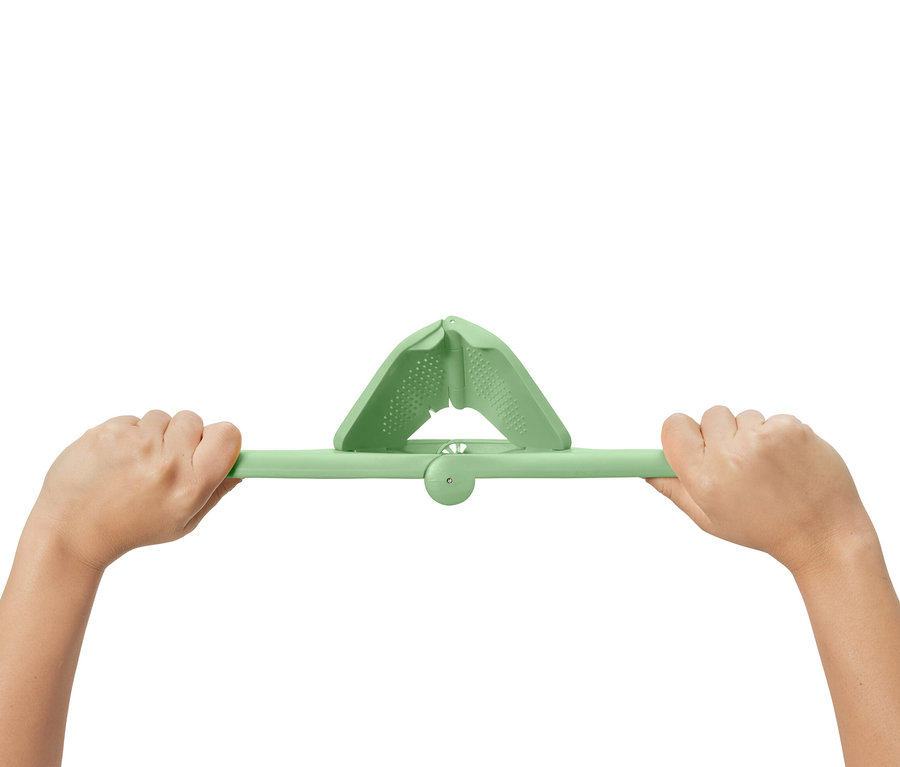 Zwei Hände halten eine grüne Platzspar-Zitruspresse.