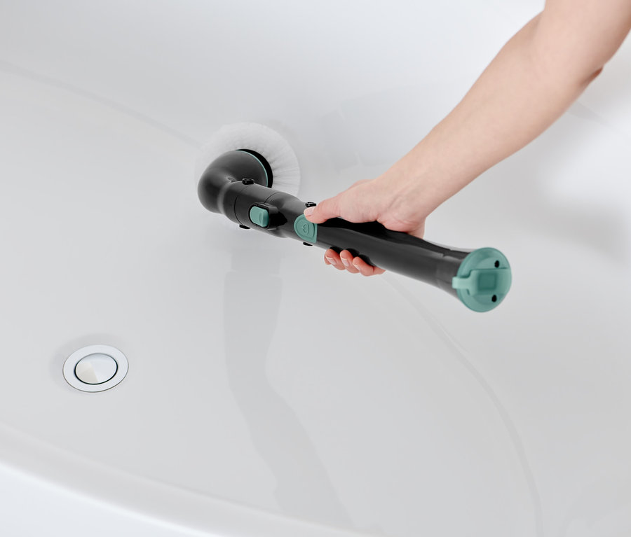 Frau reinigt weiße Badewanne mit elektrischer Profi-Reinigungsbürste.