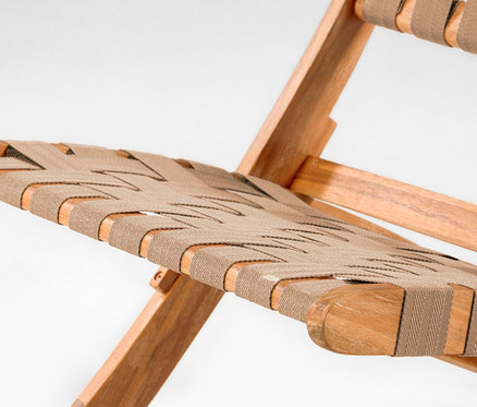 Detailansicht eines zusammenklappbaren Loungesessels mit Holzrahmen und beiger Stoffbespannung.