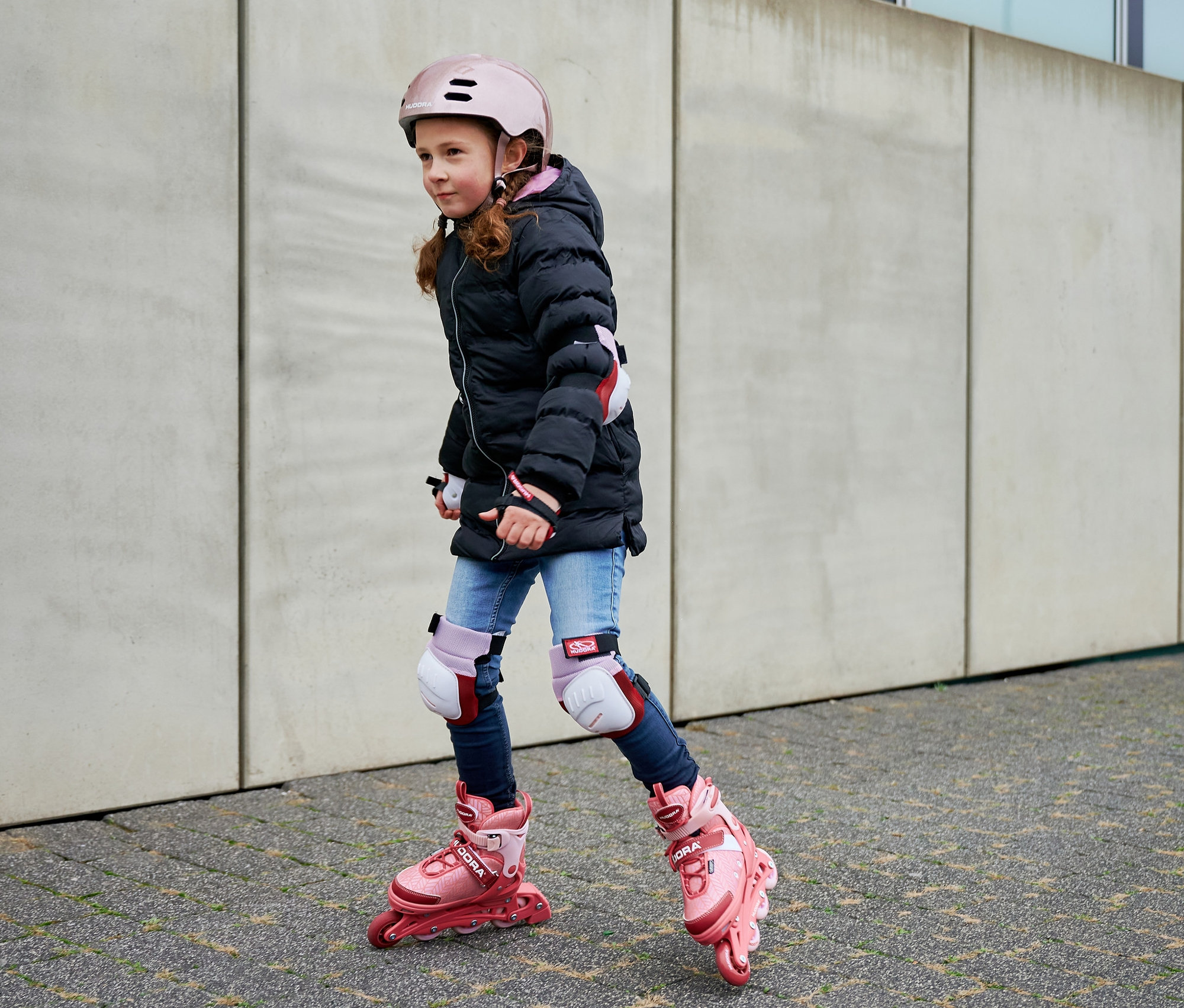 Mädchen auf HUDORA Inline Skates »Mia 2.0« mit Helm und Schützern.