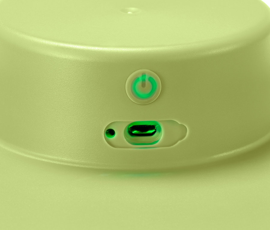 Detailaufnahme einer hellgrünen elektrischen Salatschleuder mit Akku, mit Netzschalter und Ladeanschluss.