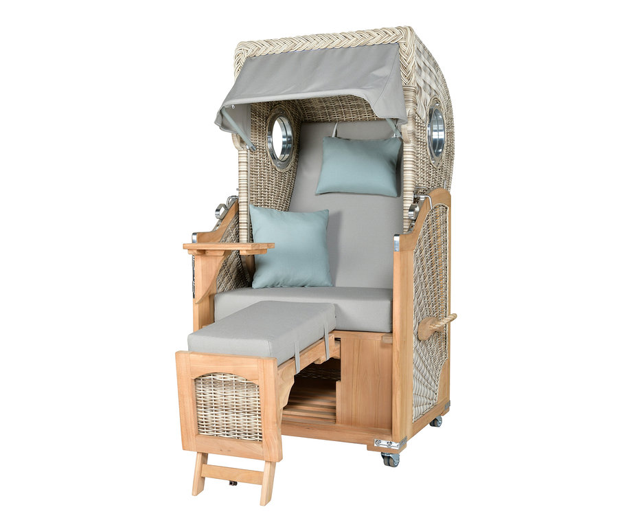 Ein deVries Teak-Strandkorb für 1 Person mit verstellbarer Fußstütze, Beistelltisch und blauen Kissen.