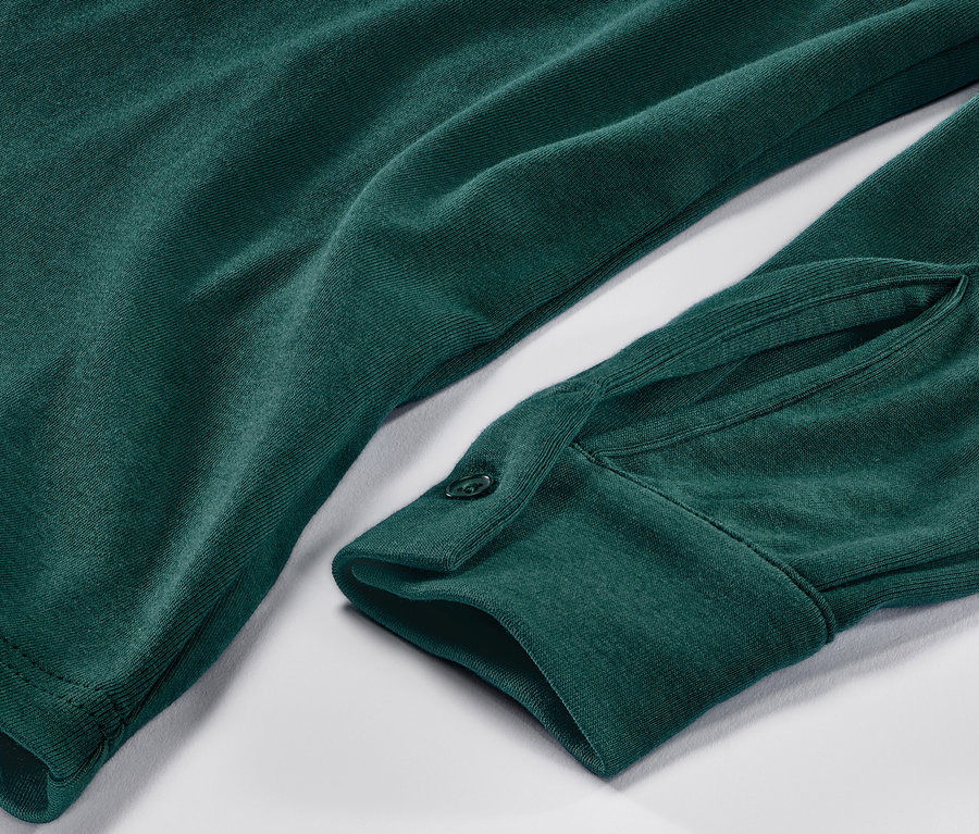 Detailansicht eines grünen Blusenshirts mit Knopfleiste.