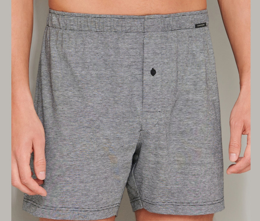 Mann trägt 2 SCHIESSER Boxershorts aus Baumwolle, schwarz und grau.
