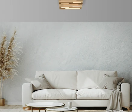 Wohnzimmer mit weißem Sofa, zwei Tischen und Deckenleuchte.