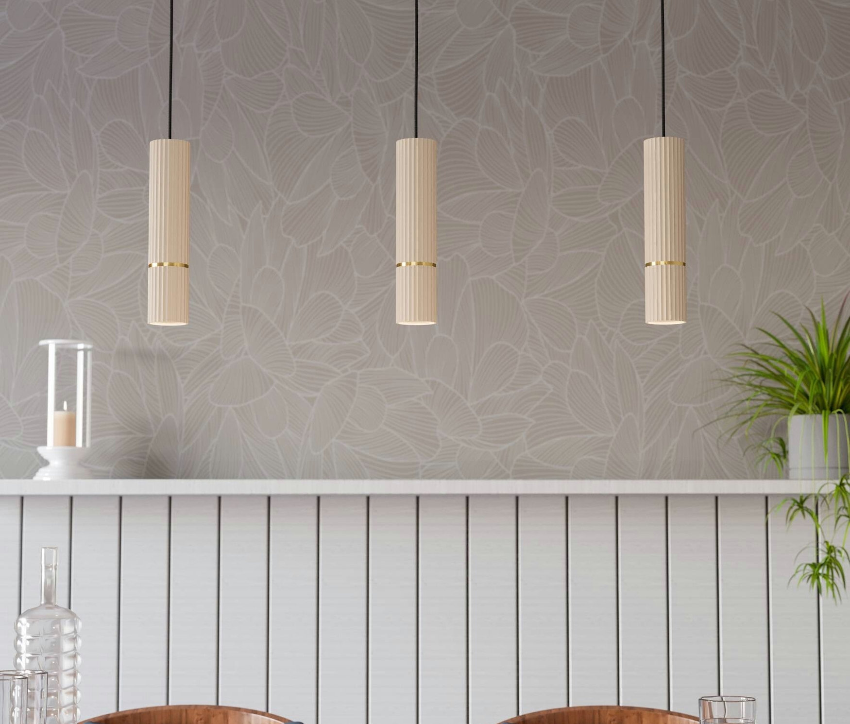 Drei Lampen hängen über einem Holztisch mit Stühlen, auf dem Wassergläser stehen.