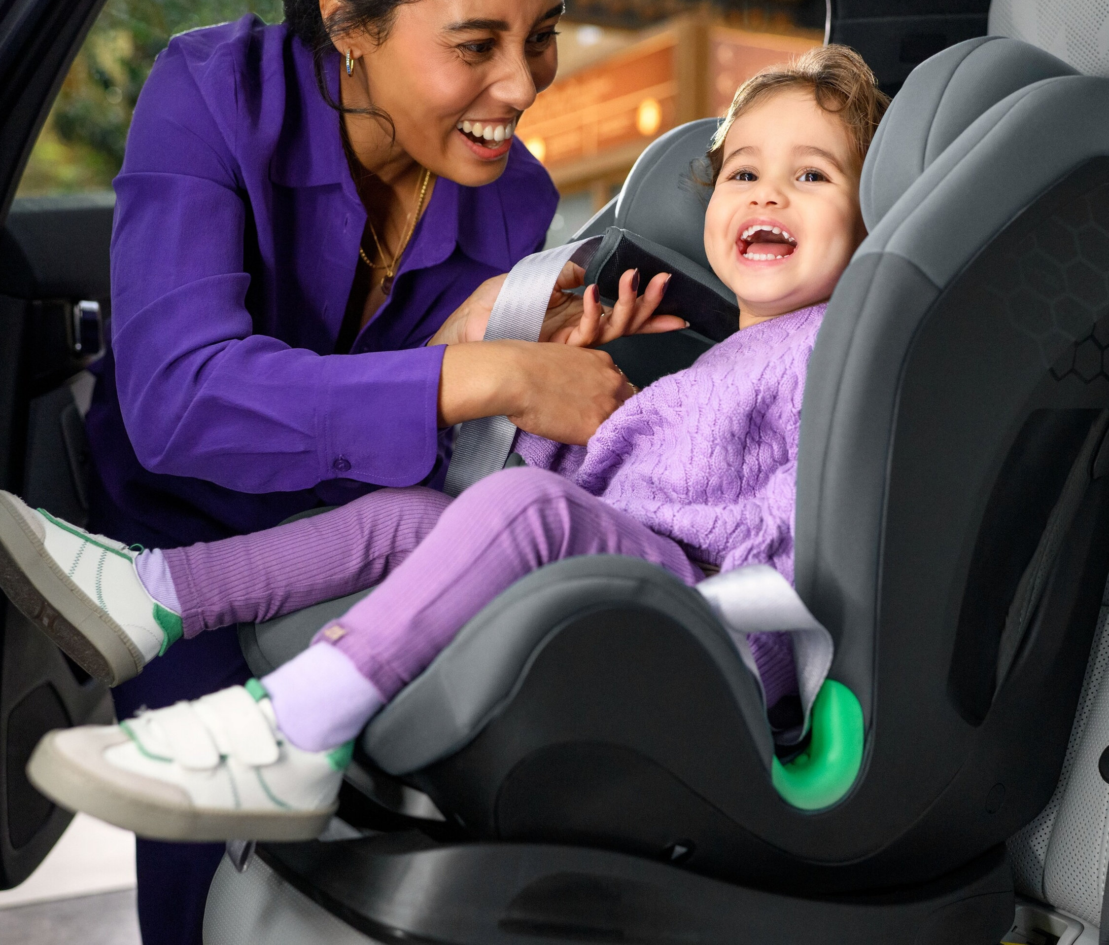 Eine Frau befestigt ein kleines Mädchen im Maxi-Cosi Kinder-Autositz »Titan S«, i-Size.