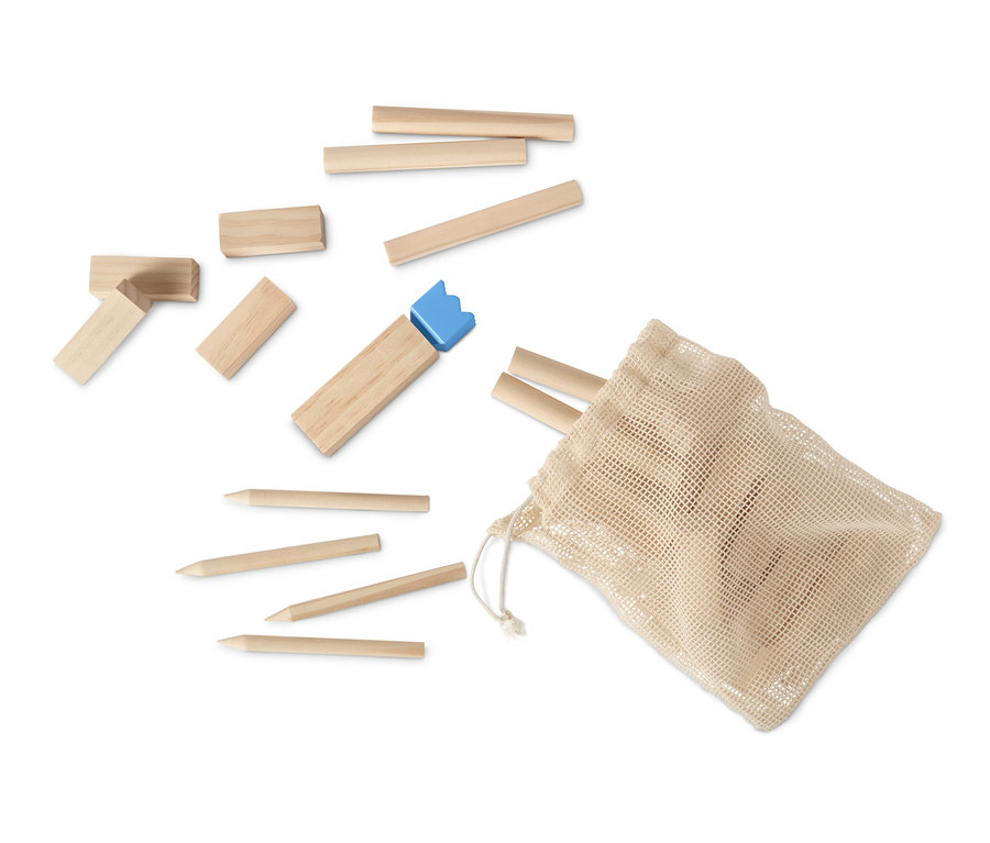 Ausgebreitetes Mini-Kubb-Spiel mit Holzblöcken, Stöcken und einer blauen Krone neben einem Kordelzugbeutel.