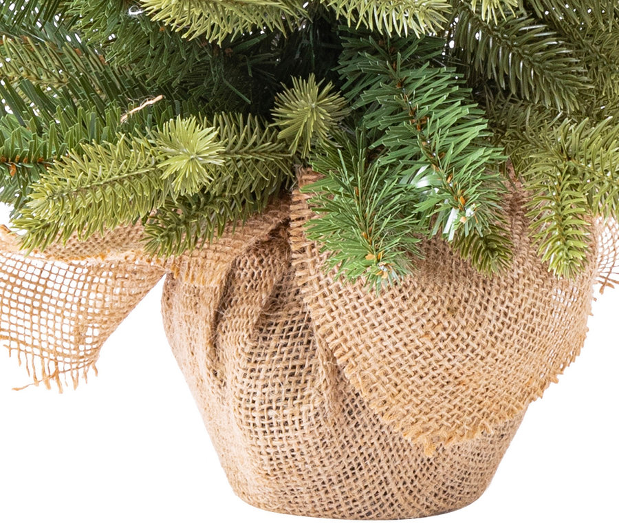 Detailaufnahme eines künstlichen Weihnachtsbaums mit Jute-Basis.