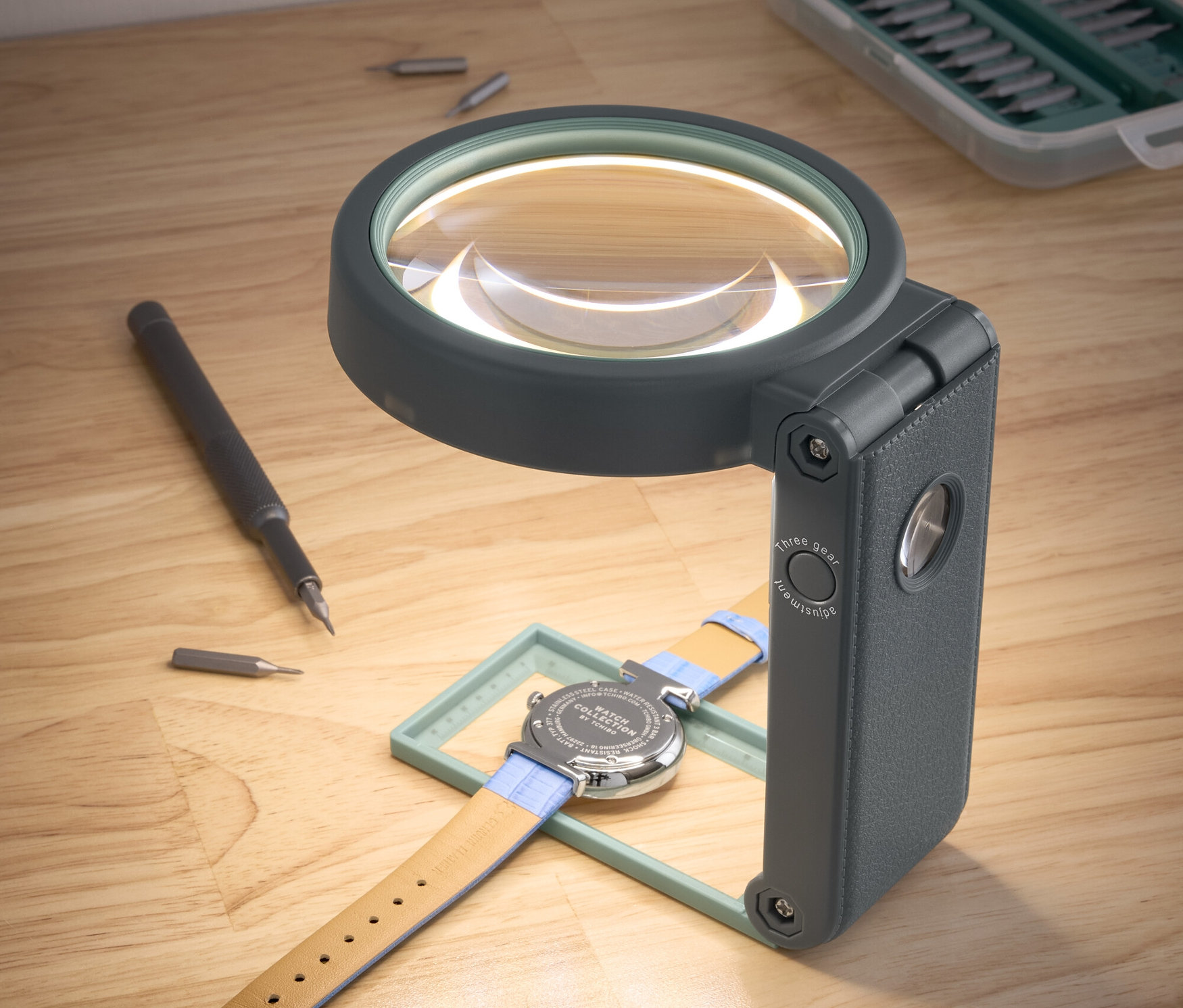 Eine Uhr liegt unter einer LED-Arbeitslupe mit Ständer.