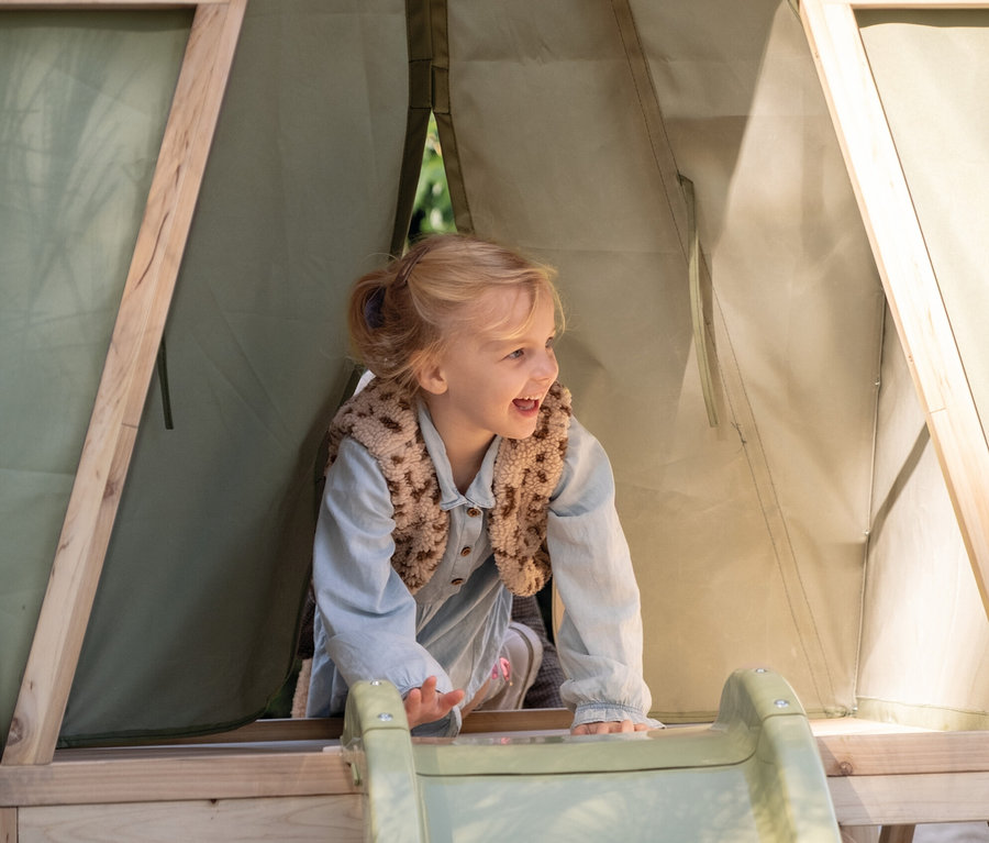 Mädchen klettert in das EXIT Spielhaus »Yuki 300« mit Rutsche.