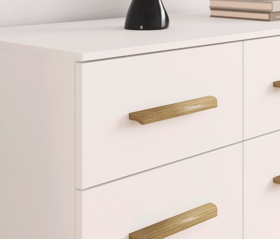Detail einer weißen Kommode mit sechs Schubladen und Holzgriffen.