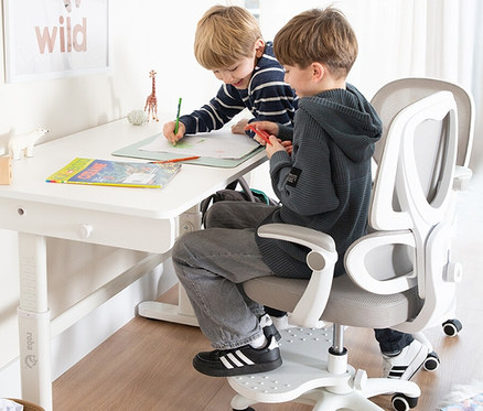 Zwei Jungen sitzen am höhenverstellbaren, weißen Roba Kinderschreibtisch Basic und malen. Einer sitzt auf einem Bürostuhl.