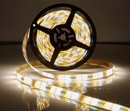 Aufnahme eines aufgerollten Smarter LED-Streifens, teilweise abgerollt, mit warmweissem Licht auf reflektierender Oberfläche.
