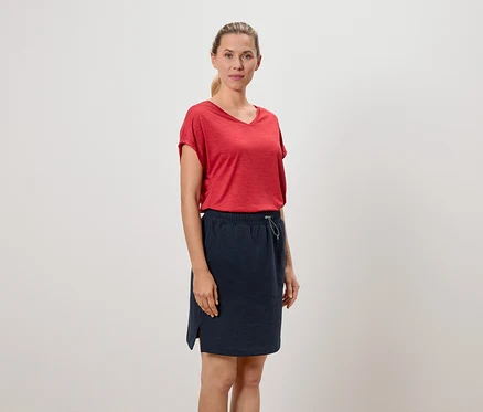 Frau trägt ein rotes T-Shirt und einen marineblauen Rock.