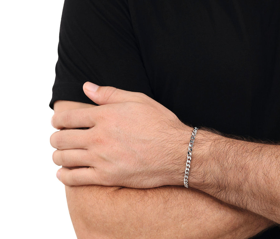 Nahaufnahme eines Mannes, der ein silbernes Gliederarmband am Handgelenk trägt und ein schwarzes T-Shirt trägt.