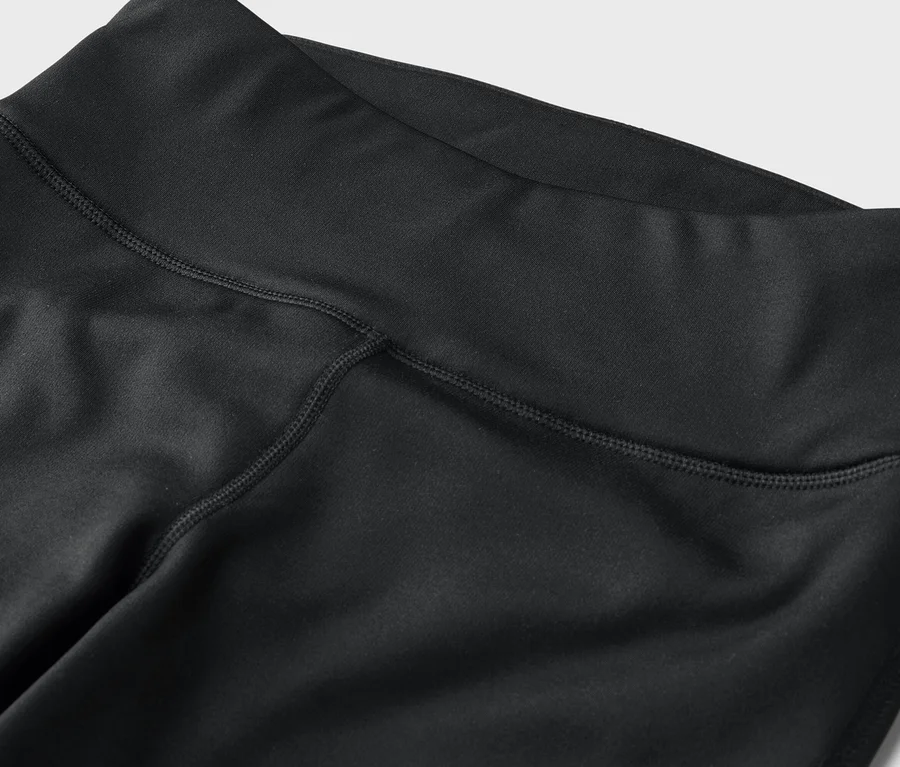 Detailaufnahme von schwarzen Leggings mit hohem Bund und sichtbaren Nähten.