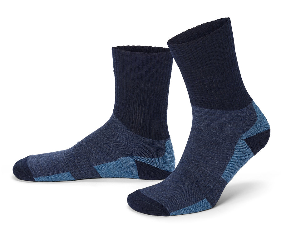 Zwei marineblaue Socken liegen auf einer weißen Oberfläche, wobei die eine Socke steht und die andere liegt.