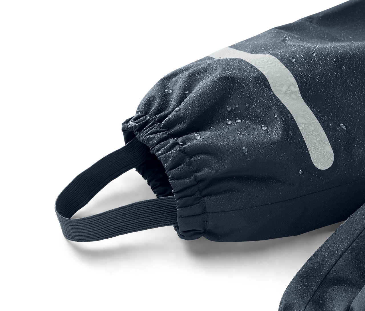 Nahaufnahme eines marineblauen Ärmels mit elastischem Bündchen und Fußsteg, der mit Wassertropfen bedeckt ist.