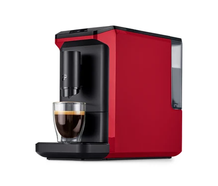 Roter »Esperto mini« Kaffeevollautomat in Lovely Red mit einer Tasse Kaffee darunter.