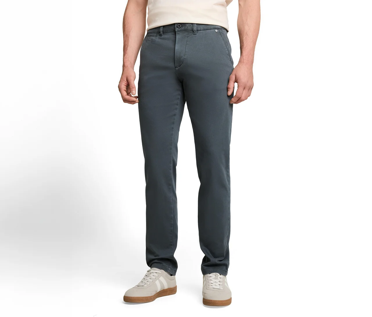 Eine Person trägt eine dunkelgraue Chinohose, ein helles T-Shirt und hellgraue Sneaker mit weißen Streifen.