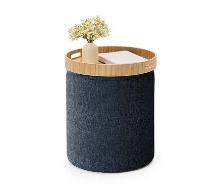 Dunkelblauer zylindrischer Aufbewahrungshocker mit einer Holzablage, auf der eine Vase mit weißen Blumen und ein Buch stehen.