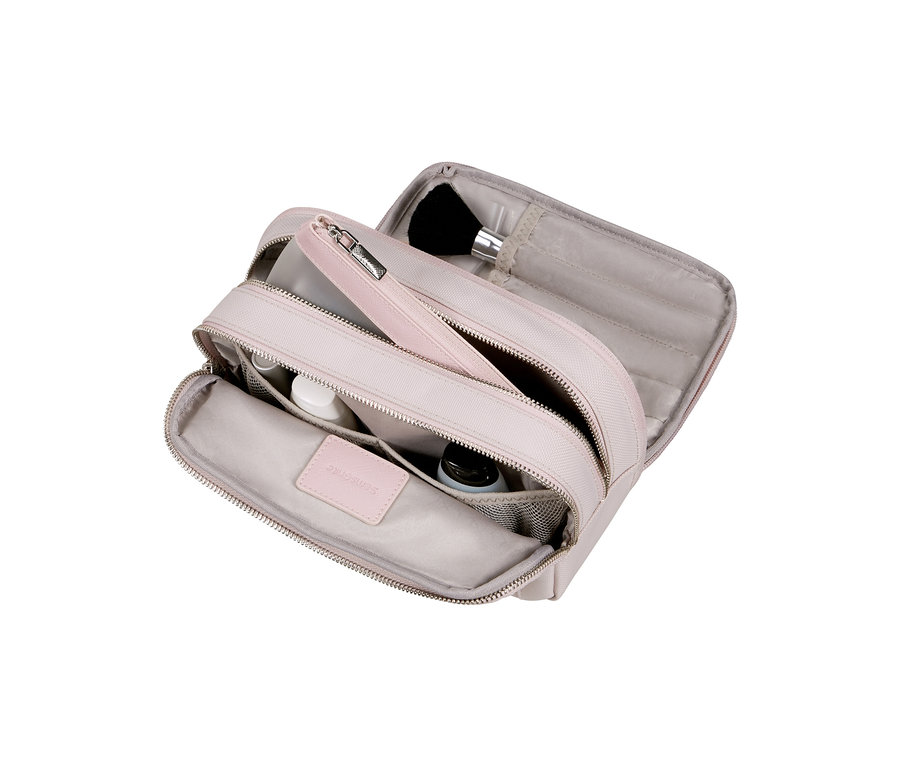 Offene rosafarbene Samsonite IMAGE Toilet Kit Pouch mit mehreren Fächern, darunter Netztaschen mit kleinen Flaschen und eine Klappe mit einem Make-up-Pinsel.