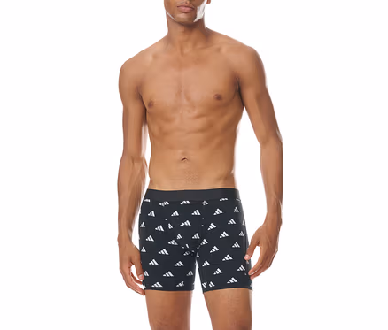 Ein oberkörperfreier Mann steht frontal da und trägt schwarze Boxershorts mit einem wiederholten weißen Adidas-Logo-Muster.