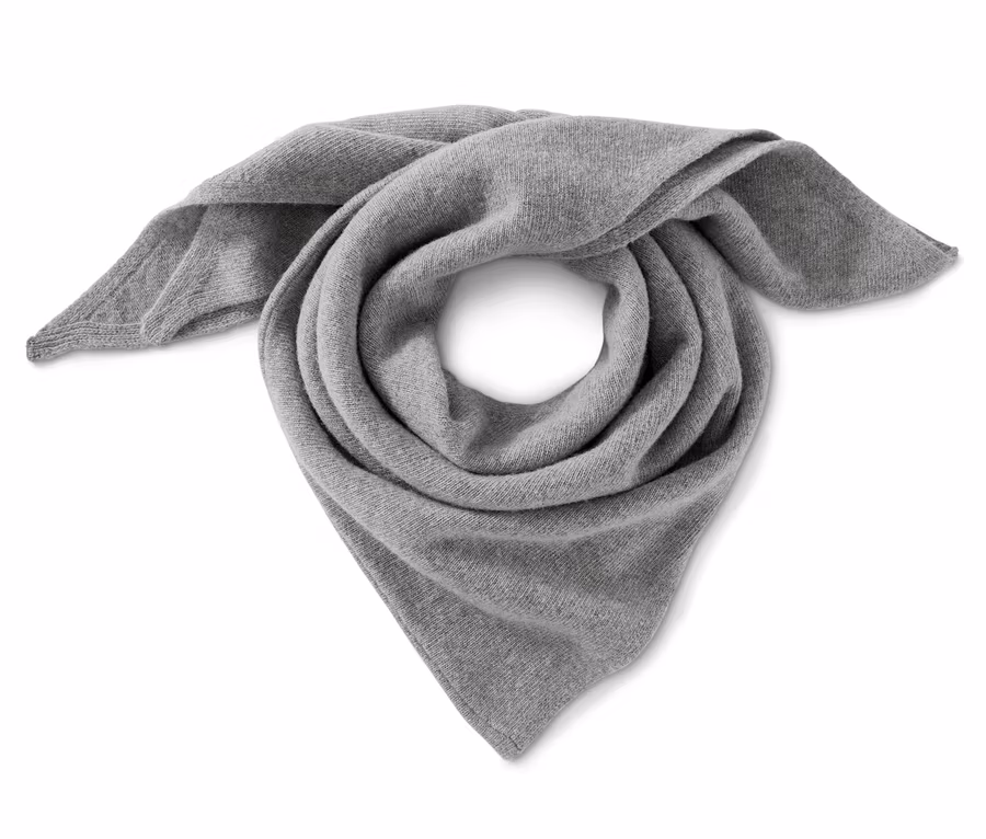 Ein grauer Strickschal mit Kaschmir ist spiralförmig gerollt.