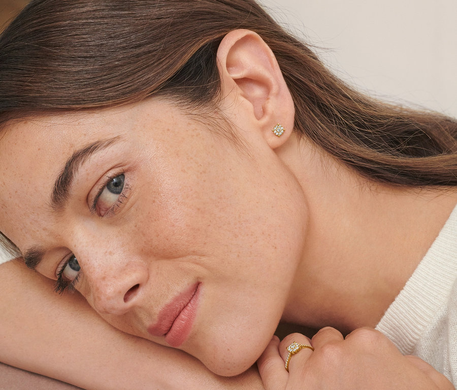Porträt einer Frau mit Ohrsteckern und einem Ring mit Diamanten aus 585 Gold.