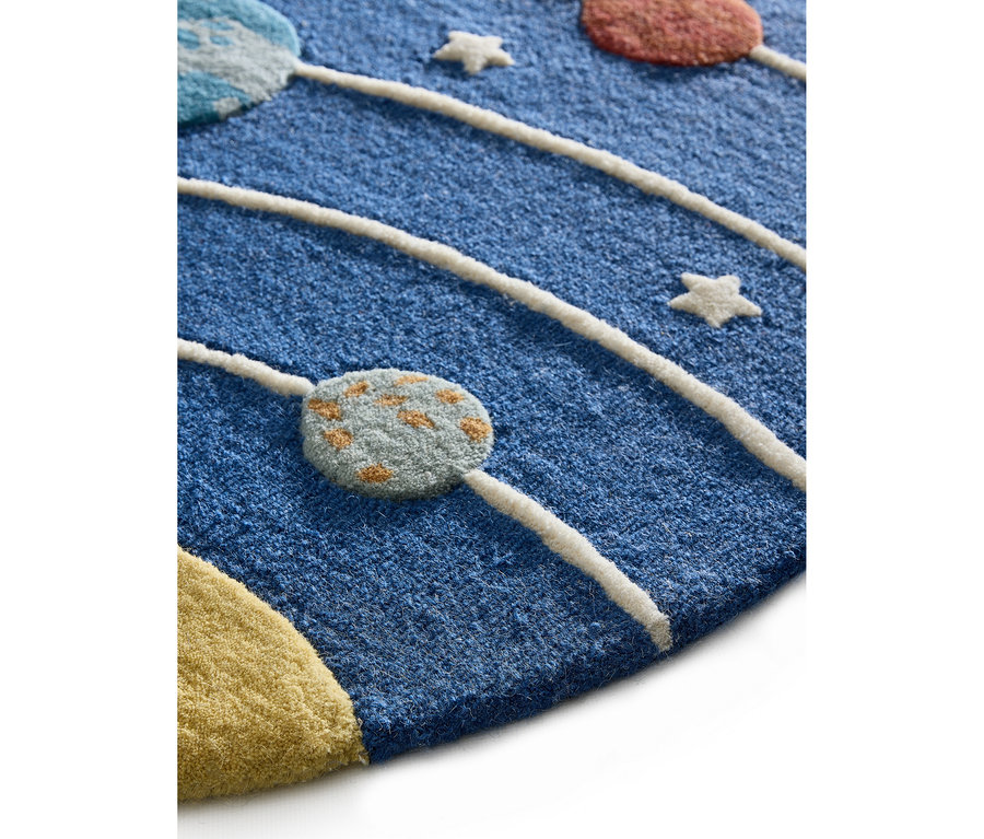 Nahaufnahme eines blauen Teppichs mit Weltraum-Motiv, der erhabene weiße Umlaufbahnen, farbige Planeten in Hellblau, Orange, Gelb und Rot sowie kleine weiße Sterne zeigt.
