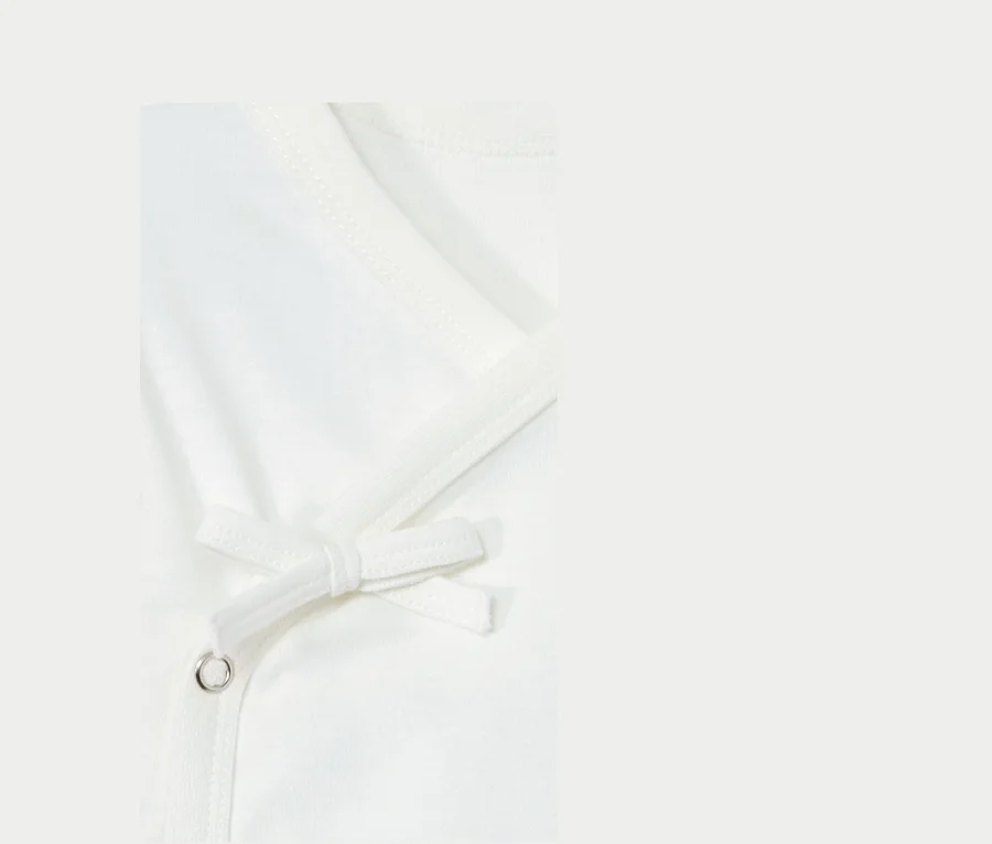 Detailaufnahme von 2 Baumwoll-Langarmbodys mit Bindeband.
