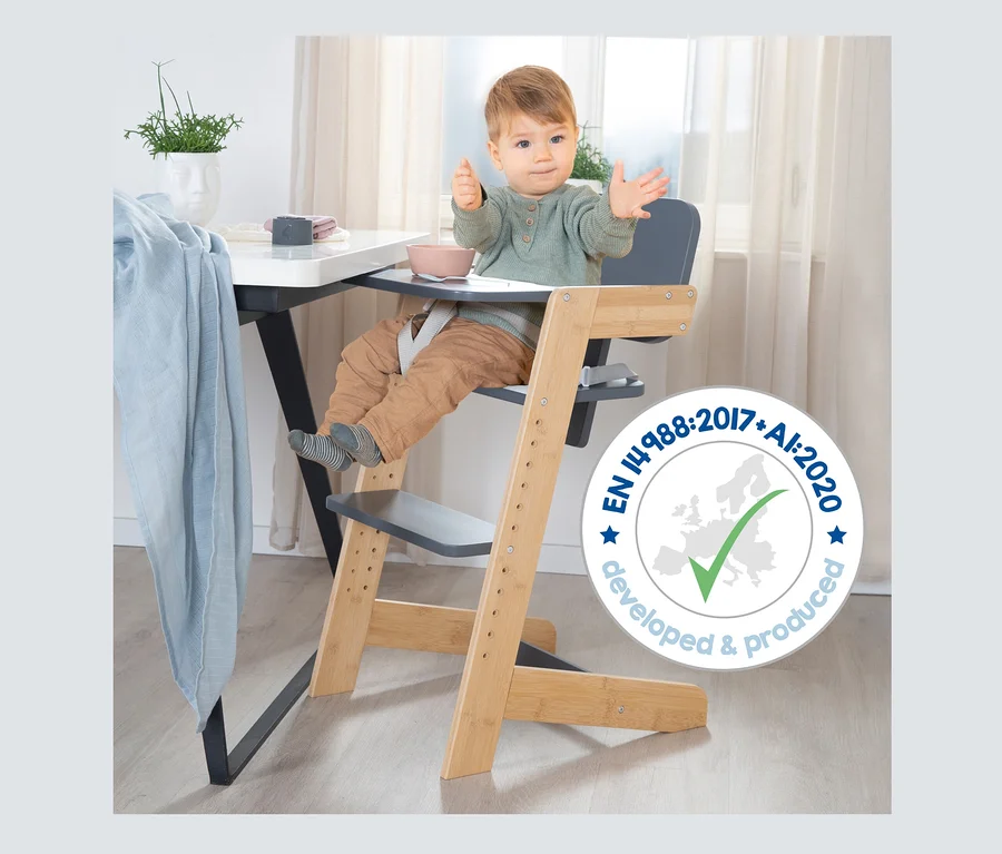 Baby sitzt im anthrazitfarbenen roba Kinderhochstuhl am Tisch.