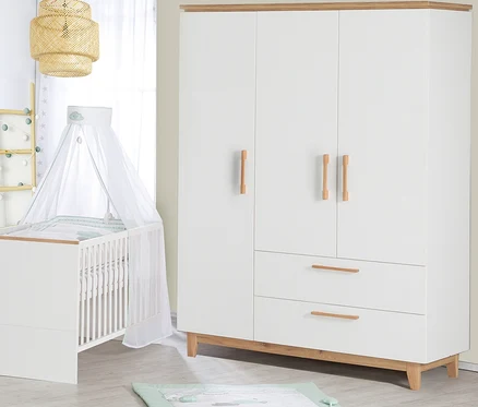 Ein Kinderzimmer mit einem weißen Kinderbett mit Himmel, einem weißen dreitürigen Kleiderschrank und einer Spieldecke auf dem Boden.