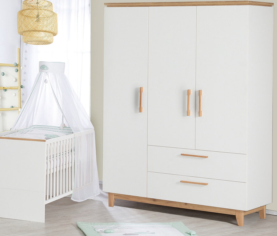 Ein Kinderzimmer mit einem weißen Kinderbett mit Himmel, einem weißen dreitürigen Kleiderschrank und einer Spieldecke auf dem Boden.