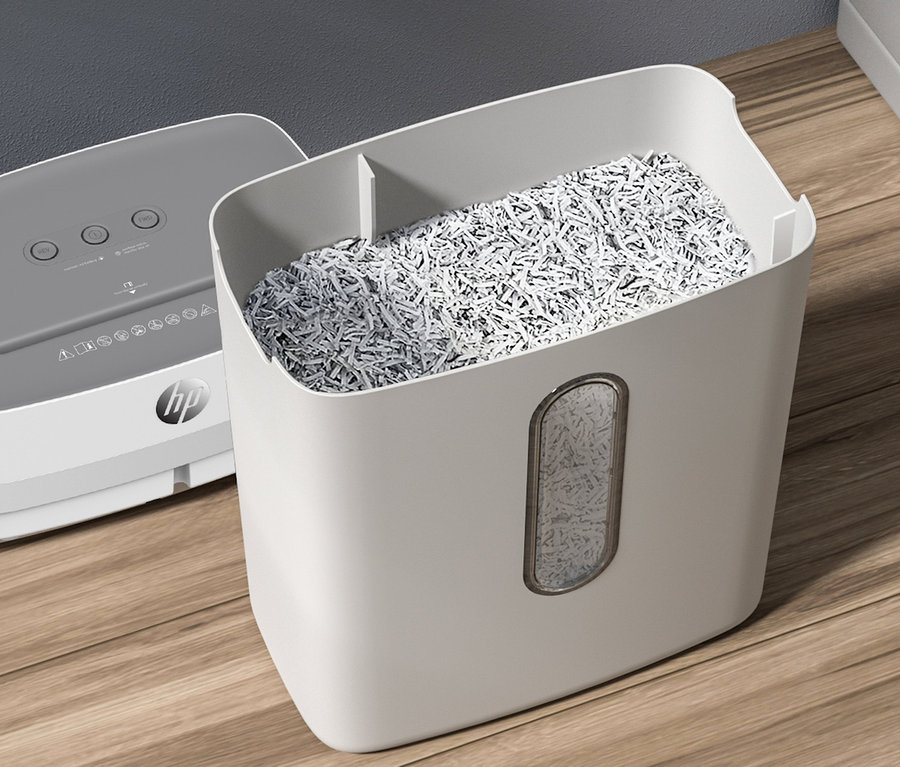 Detail eines grauen HP OneShred 12CC Aktenvernichters mit vollem Behälter mit geschreddertem Papier.